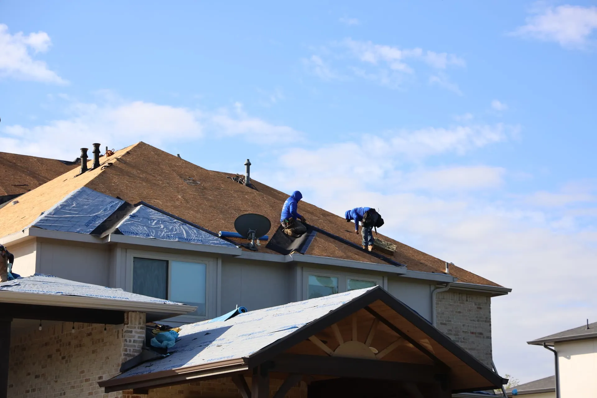 Crew members preparing roof slopes above the backyard patio in Prosper