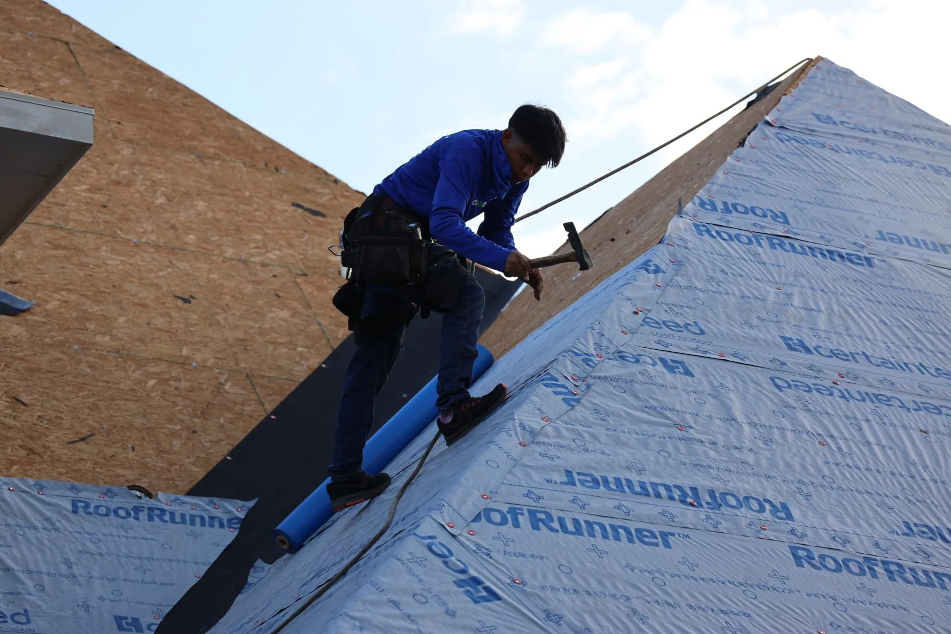 Good Faith Roofing crew member securing synthetic underlayment on the Prosper roof