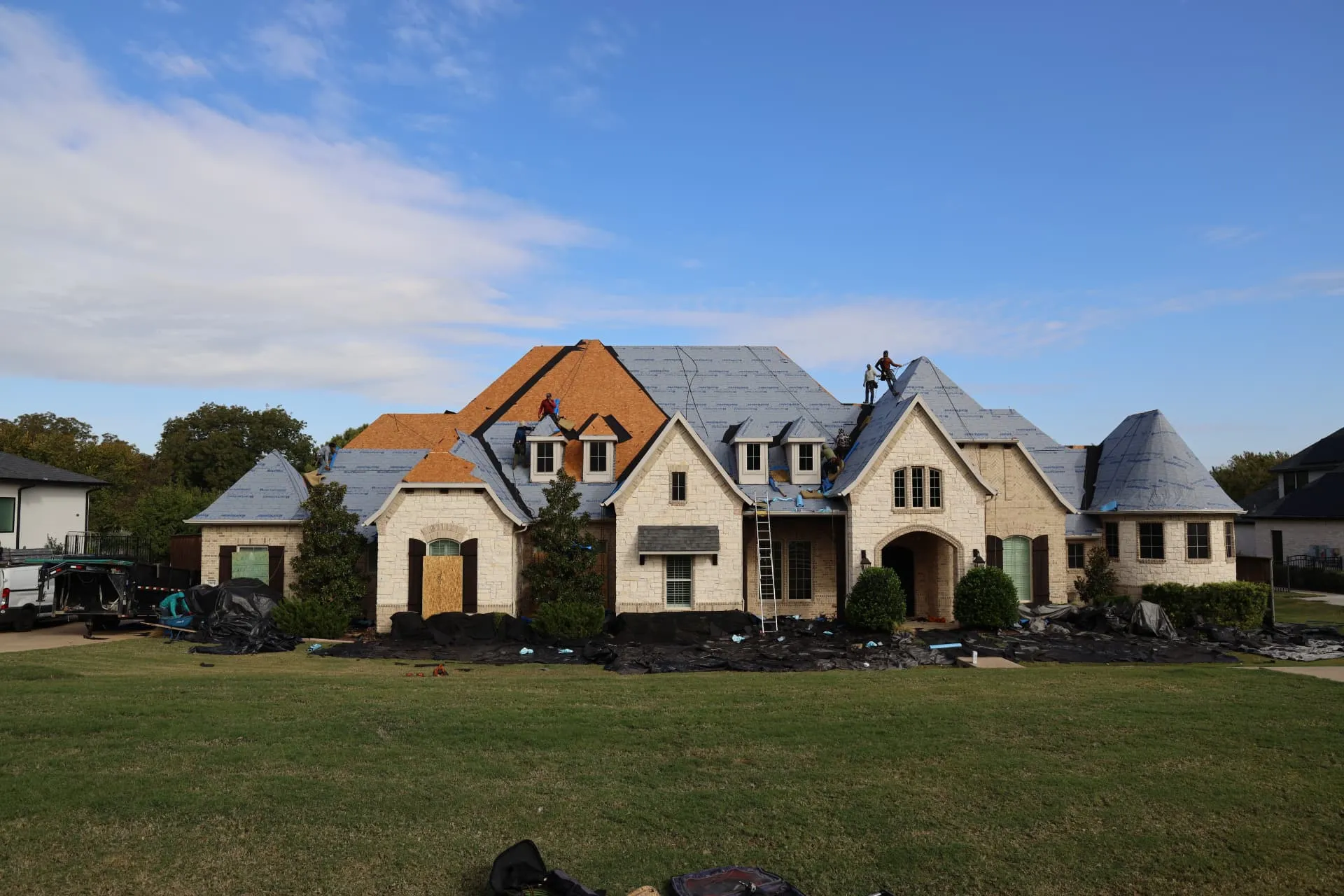 Wide front view of the Prosper home during roof replacement
