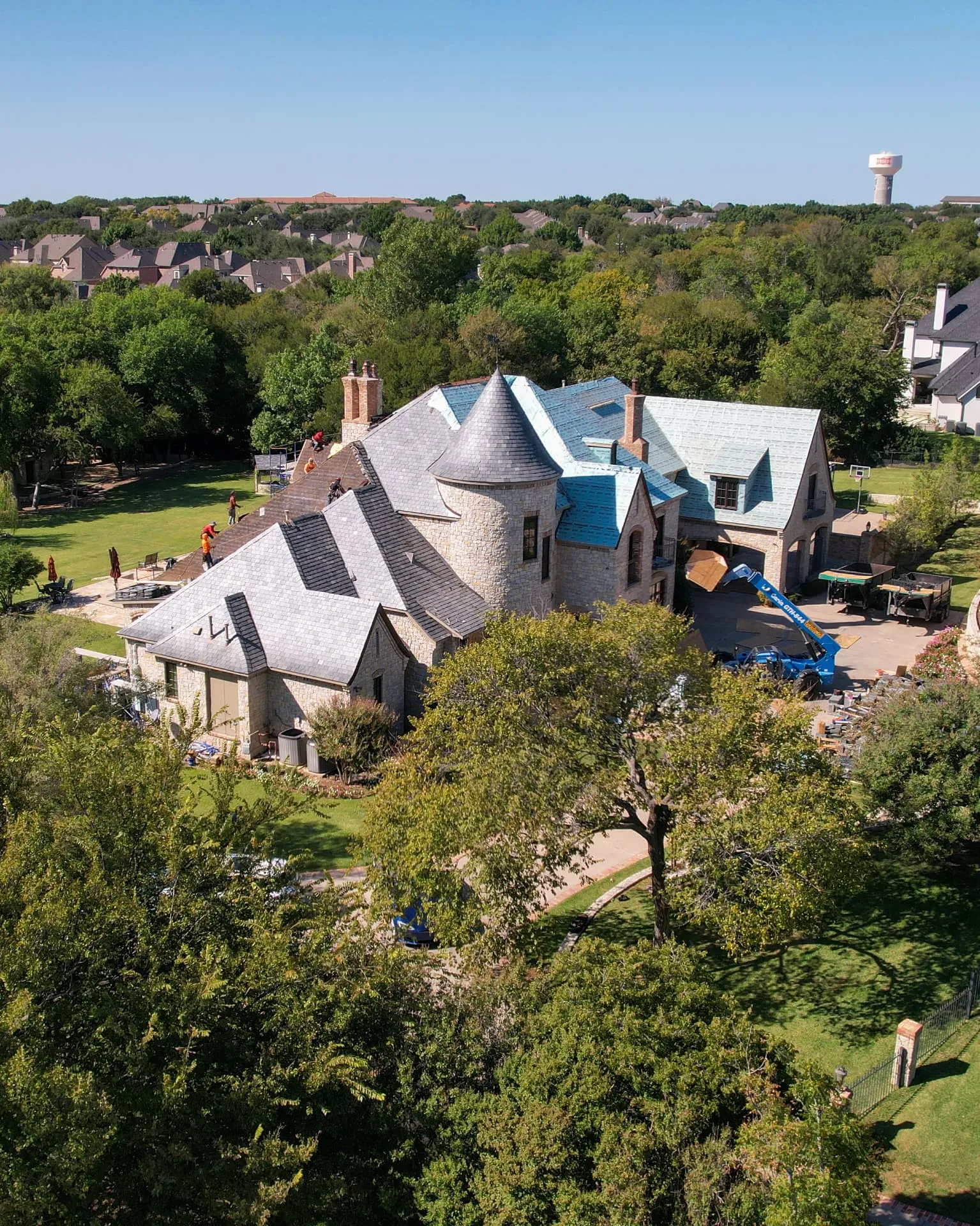 Houston Texas brick home with a dark shingle roof surrounded by pines and dense green landscaping