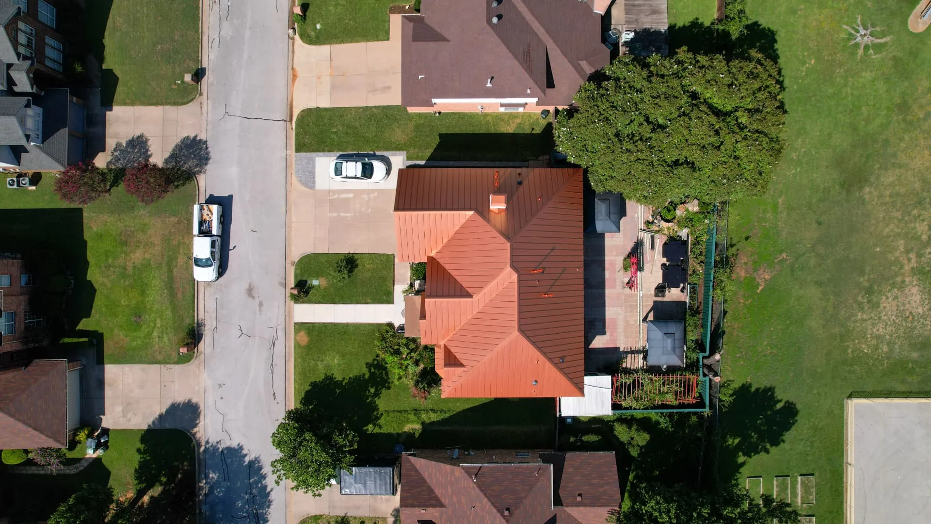 Established Dallas neighborhood home with a mature tree canopy and a shingle roof