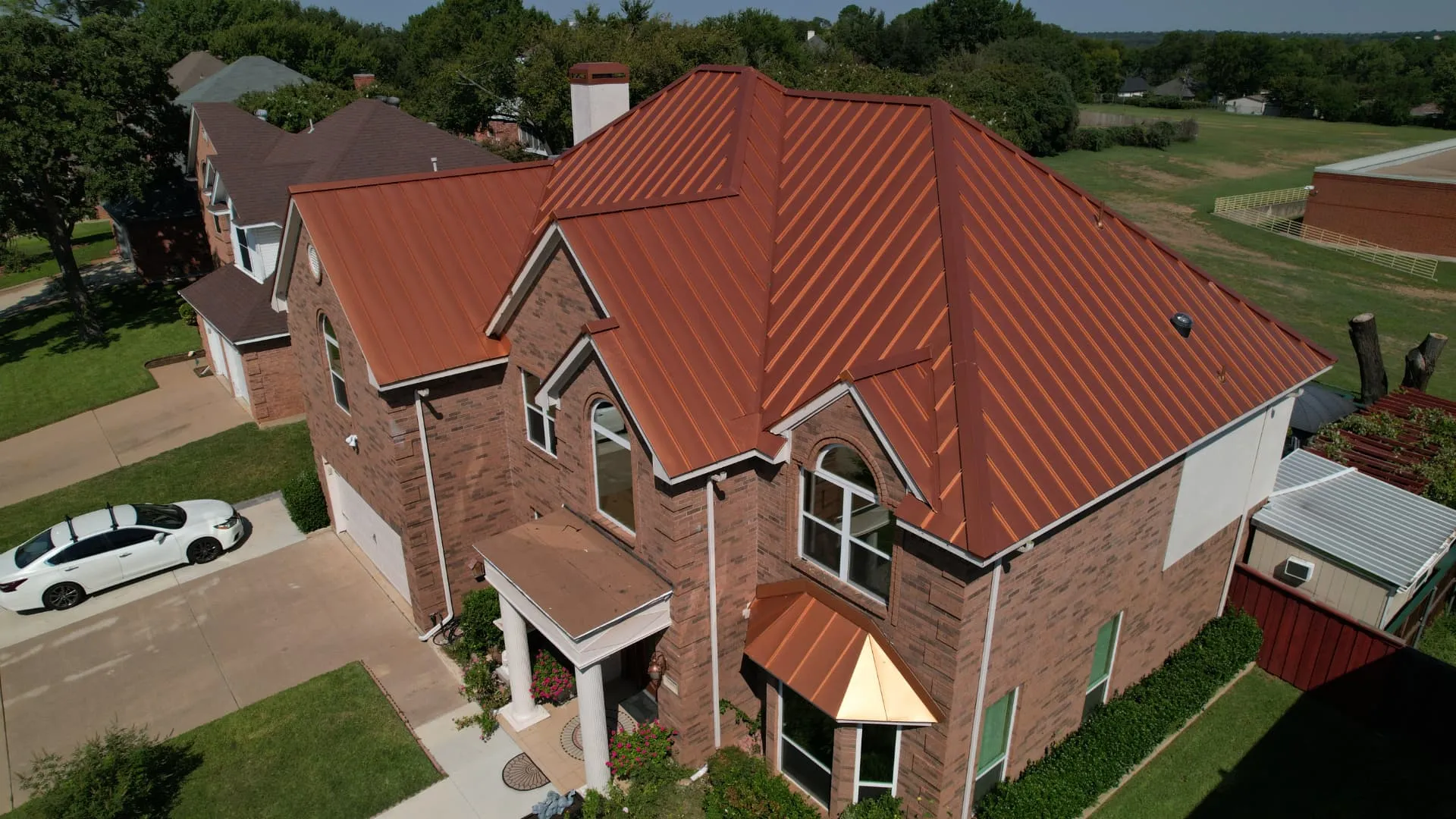 Rear elevation of a copper standing seam roof with a curved copper bay window cap