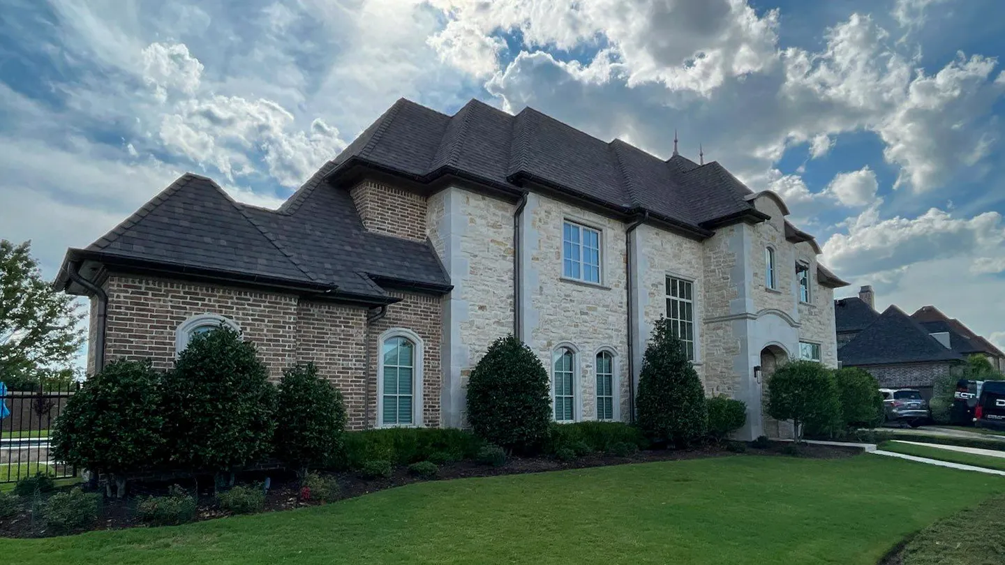 Little Elm Texas stone and brick two-story home with a brown dimensional shingle roof
