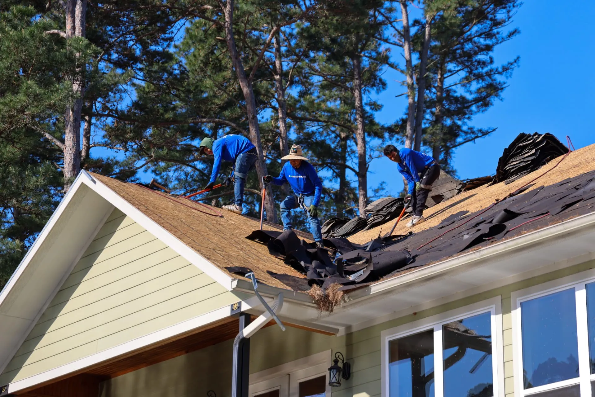 Good Faith Roofing crew tearing off old shingles on an insurance-approved roof replacement