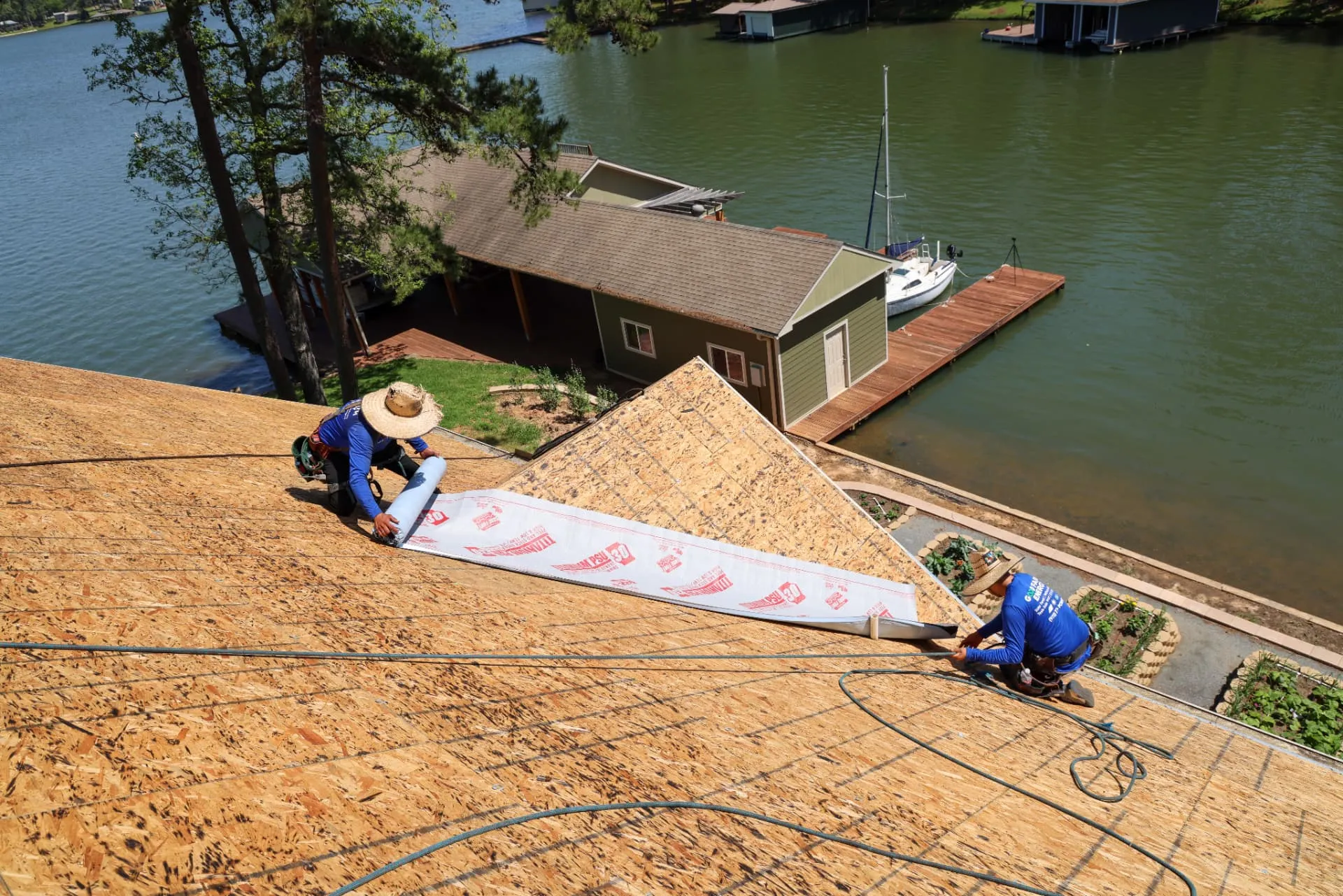 Roofer rolling out underlayment during a roof replacement after storm damage