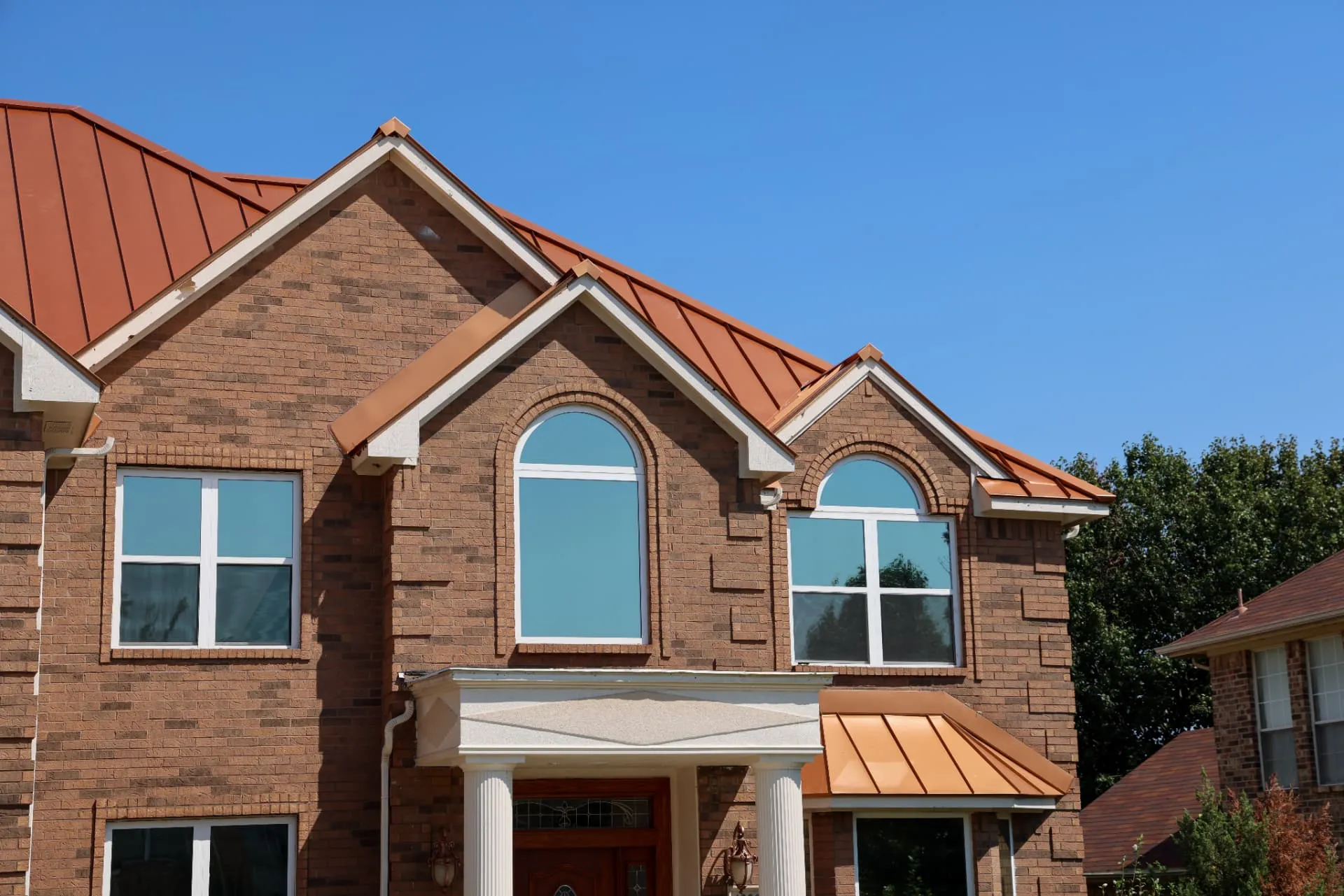 Gutters and downspouts running along the roof edge of a brick North Texas home