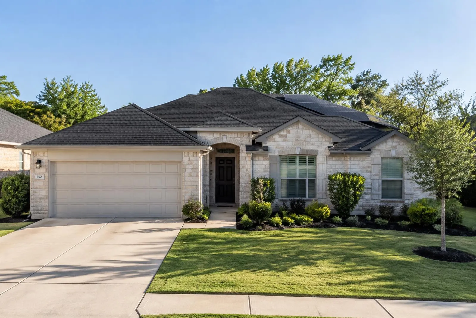 Addison ranch home with a newly replaced dark shingle roof and reinstalled black solar panels